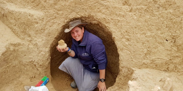Archaeologist Shira Bloch holding a 2000-year old vessel discovered in the excavation. (Credit: Israel Antiquities Authority)