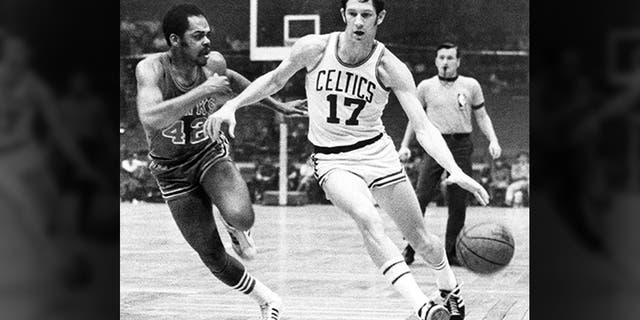 波士顿凯尔特人队的John Havlicek(17岁)在1970年NBA波士顿NBA篮球比赛期间用他的身体从亚特兰大老鹰队的Walt Hazzard(42)保护球。