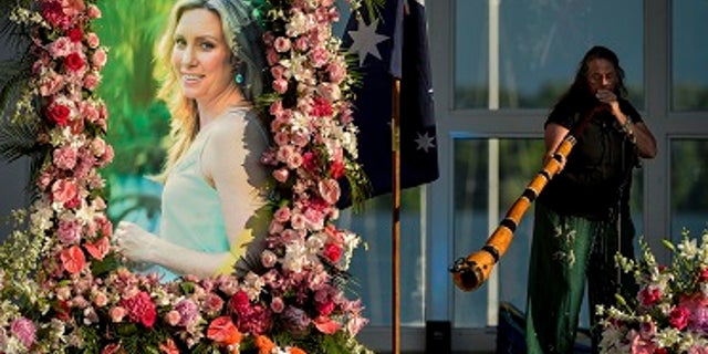 In this Aug. 11, 2017, file photo, Johanna Morrow plays the didgeridoo during a memorial service for Justine Ruszczyk Damond at Lake Harriet in Minneapolis.