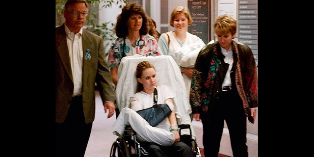 Kacey Ruegsegger, 17, is wheeled from a Denver hospital by Patty Anderson, center, after being released in May 1999. 
