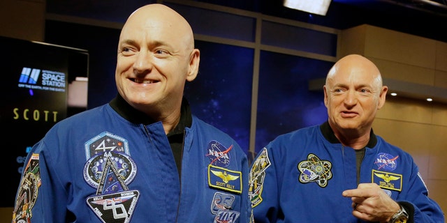 In this archival photo from March 4, 2016, NASA astronaut Scott Kelly, left, and his identical twin, Mark, are standing in front of a press conference in Houston.