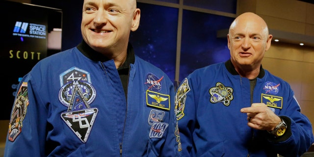 In this March 4, 2016 file photo, NASA astronaut Scott Kelly, left, and his identical twin, Mark, stand together before a news conference in Houston.