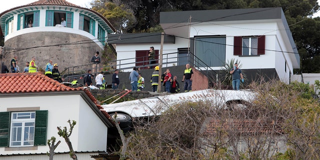 Rescue workers stand next to the wreckage of the bus after Wednesday's accident. REUTERS/Duarte Sa - RC1A00A52330