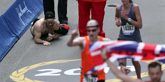 Micah Herndon, of Tallmadge, Ohio, crawls to the finish line in the 123rd Boston Marathon on Monday, April 15, 2019, in Boston. (AP Photo/Charles Krupa)