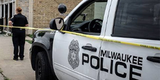 A Milwaukee police cruiser is seen waiting outside a crime scene.