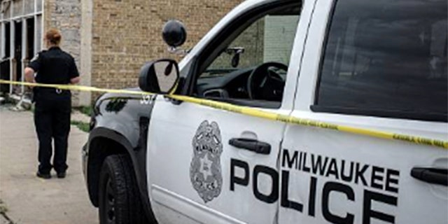 A Milwaukee police cruiser is seen waiting outside a crime scene.
