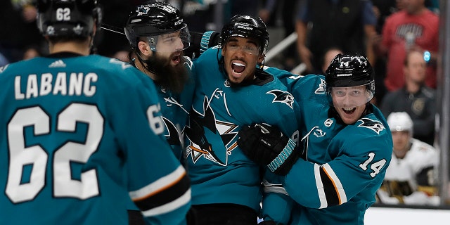 From left, San Jose Sharks' Kevin Labanc (62), Brent Burns, Evander Kane, and Gustav Nyquist (14) celebrate a goal by Joe Pavelski, not seen, against the Vegas Golden Knights during the first period of Game 1 of an NHL hockey first-round playoff series Wednesday, April 10, 2019, in San Jose, Calif. (AP Photo/Ben Margot)