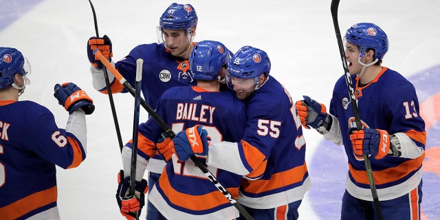 New York Islanders right wing Josh Bailey is hugged by defenseman Johnny Boychuk (55) as teammates celebrate after Bailey scored in overtime against the Pittsburgh Penguins during Game 1 of an NHL hockey first-round playoff series, Wednesday, April 10, 2019, in Uniondale, N.Y. The Islanders won 4-3. (AP Photo/Julio Cortez)