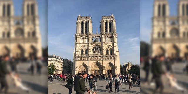 In the image, a man lifts and swings a smiling little girl in front of the 800-year-old landmark.