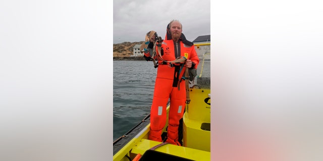 Norwegian Joergen Ree Wiig holds the whale harness after it was removed from a beluga whale off the northern Norwegian coast Friday, April 26, 2019.