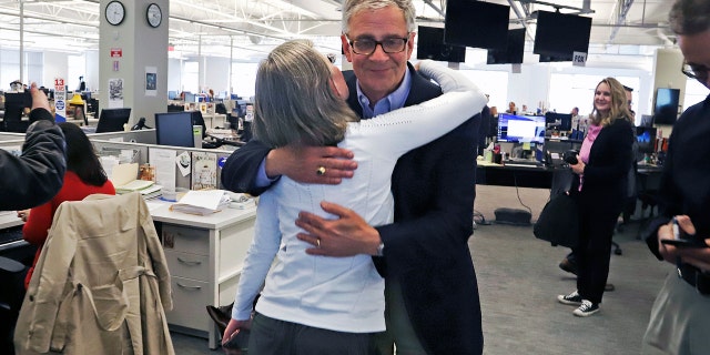 Pittsburgh Post Gazette retired Executive Editor David Shribman, center right, hugs city editor Lillian Thomas after the paper was awarded the Pulitzer Prize for Breaking News Reporting. (AP Photo/Gene J. Puskar)