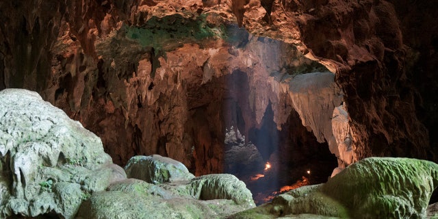 This undated photo provided by the Callao Cave Archaeology Project in April 2019 shows Callao Cave on Luzon Island of the Philippines, where the fossils of Homo luzonensis were discovered. This view is taken from the rear of the first chamber of the cave, where the fossils were found, in the direction of the second chamber. (Callao Cave Archaeology Project via AP)