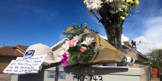 Flowers and notes are arranged atop a mailbox on April 23, 2019, in tribute to a mail carrier who police say was killed outside an adjacent home in Albuquerque, N.M. (Associated Press)