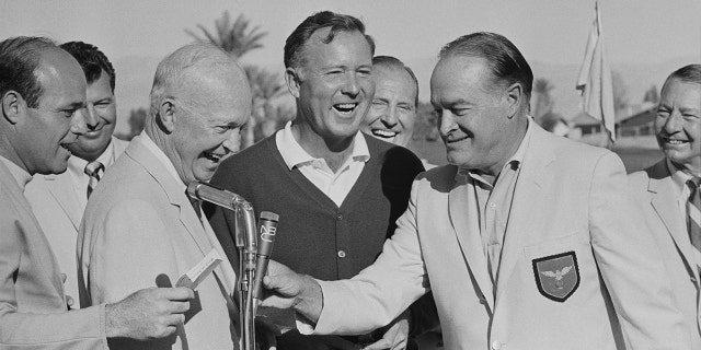 Former U.S. President Dwight D. Eisenhower and Bob Hope stand with golfer Tom Nieporte (center), who has just won the 1967 Bob Hope Desert Classic.