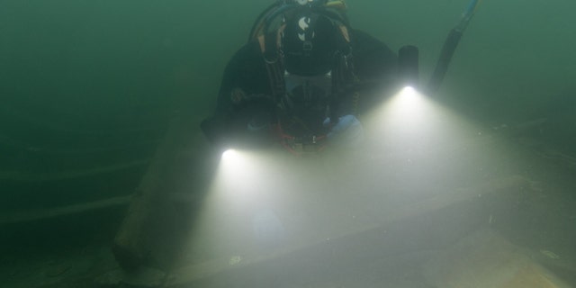 A diver examines the wreck.
