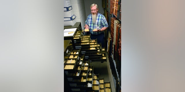 Historian Randy Marcum and the unclaimed medals at the West Virginia State Archives.