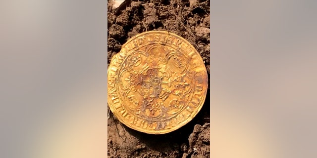 One of the gold coins. The four hunters struck gold in a field in Buckinghamshire and were initially delighted to find 12 ornately decorated silver Edward I and II coins. Over four days they excavated 557 coins - including 12 ultra-rare full gold nobles from the time of the Black Death. (Credit: SWNS)