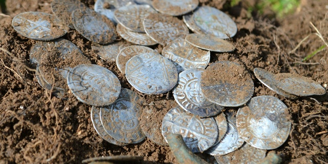 Some of the silver coins. The men - more used to digging up shotgun shells and thimbles than treasure - were astonished to find coin after coin from the hidden ancient hoard. (Credit: SWNS)