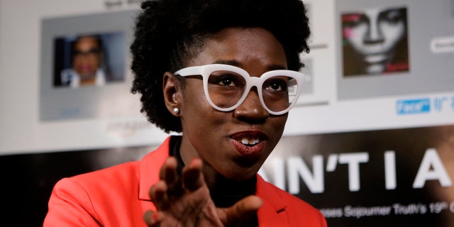 In this Wednesday, Feb. 13, 2019, photo, Massachusetts Institute of Technology facial recognition researcher Joy Buolamwini takes questions from reporters at the school, in Cambridge, Mass. Buolamwini's research has uncovered racial and gender bias in facial analysis tools sold by companies such as Amazon that have a hard time recognizing certain faces, especially darker-skinned women. (AP Photo/Steven Senne)