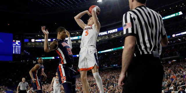 Virginia's Kyle Guy (5) takes a shot as Auburn's Samir Doughty (10) was called foul during the second half in the semifinals of the Final Four NCAA college basketball tournament, Saturday, April 6, 2019, in Minneapolis. (Associated Press)