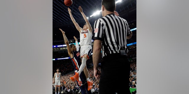 Virginia's Kyle Guy (5) takes a shot as Auburn's Samir Doughty (10) was called for a foul with 0.6 seconds left in the semi-final. (AP Photo/David J. Phillip)