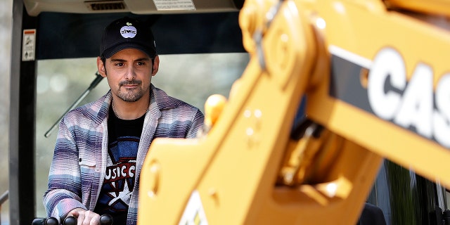 Country music star Brad Paisley operates a backhoe as he breaks ground for The Store, a free grocery store for people in need, on Wednesday, April 3, 2019, in Nashville, Tenn.