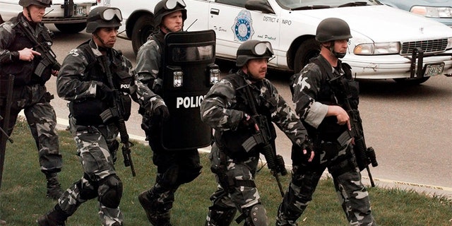 Members of a police SWAT team march to Columbine High School on April 20, 1999.