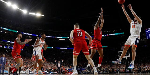 Virginia's Ty Jerome (11) makes a shot against Texas Tech's Kyler Edwards (0) during the second half in the championship of the Final Four NCAA college basketball tournament, Monday, April 8, 2019, in Minneapolis. (AP Photo/David J. Phillip)