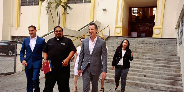 California Gov. Gavin Newsom, second from right, walks out with San Salvador Mayor Ernesto Muyshondtof, far left, after they visited the tomb of Archbishop Oscar Romero at Metropolitan Cathedral in San Salvador, El Salvador.