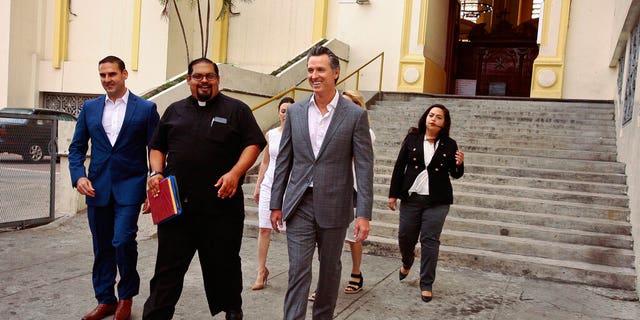 California Gov. Gavin Newsom, second from right, walks out with San Salvador Mayor Ernesto Muyshondtof, far left, after they visited the tomb of Archbishop Oscar Romero at Metropolitan Cathedral in San Salvador, El Salvador.