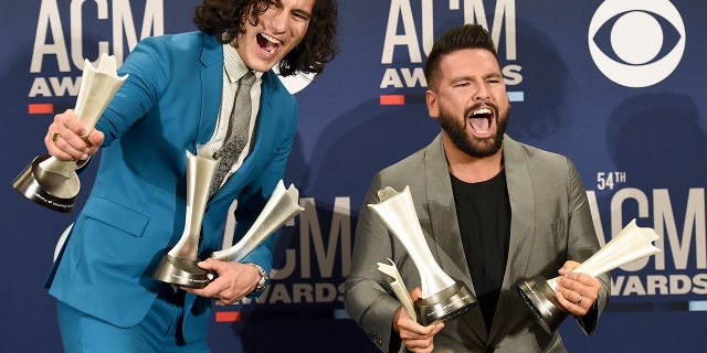 Dan Smyers, left, and Shay Mooney, of Dan + Shay, pose in the press room with the song awards of the year and the year title for "Tequila" and the duo of the year at the 54th Academy of Country Music Award ceremony at the MGM Grand Garden Arena on Sunday, April 7, 2019 in Las Vegas. (Photo of Jordan Strauss / Invision / AP)