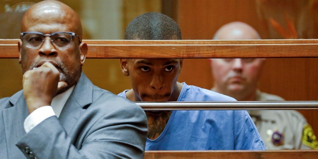 Eric Holder, the suspect in the killing of rapper Nipsey Hussle, is seen in Los Angeles County Superior Court with his attorney Christopher Darden, left, on Thursday. (Associated Press)