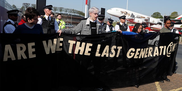 Police surround environmental protestors near Heathrow Airport in London on Friday.