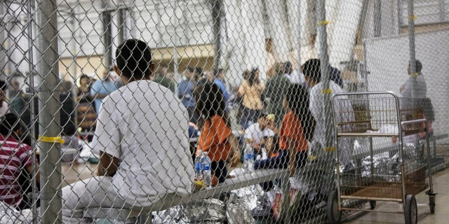 FILE - In this June 17, 2018 file photo provided by U.S. Customs and Border Protection, people who've been taken into custody related to cases of illegal entry into the United States, sit in one of the detainment centers at a facility in McAllen, Texas. . (U.S. Customs and Border Protection's Rio Grande Valley Sector via AP)