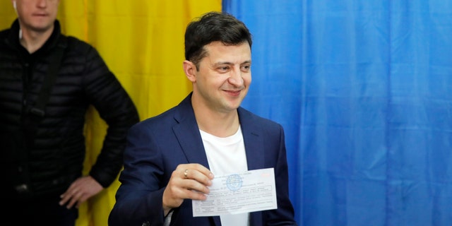 Ukrainian comedian and presidential candidate Volodymyr Zelenskiy shows his vote before reconciling his poll at a polling station during the second round of presidential elections in Kiev, Ukraine, Sunday, April 21, 2019. The key issues in the election have been corruption, the economy and how to will end the conflict with Russian-backed rebels in eastern Ukraine. (AP Photo / Vadim Ghirda)