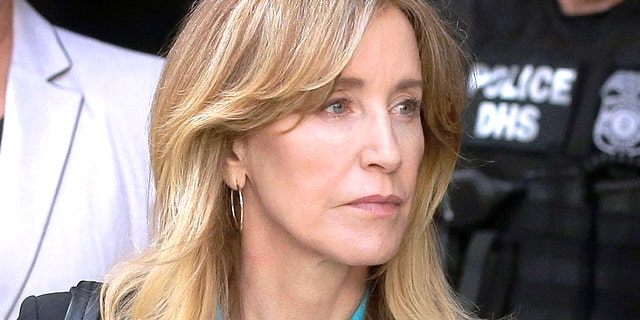 FILE - In this April 3, 2019 file photo, actress Felicity Huffman arrives at federal court in Boston to face charges in a nationwide college admissions bribery scandal. In a court filing on Monday, April 8, 2019, Huffman agreed to plead guilty in the cheating scam.