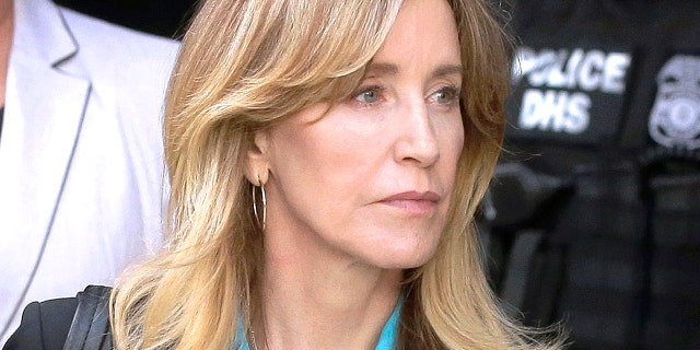 FILE - In this April 3, 2019 file photo, actress Felicity Huffman arrives at federal court in Boston to face charges in a nationwide college admissions bribery scandal. In a court filing on Monday, April 8, 2019, Huffman agreed to plead guilty in the cheating scam.