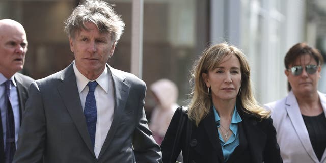 Actress Felicity Huffman arrives holding hands with her brother Moore Huffman Jr., left, at federal court in Boston on Wednesday, April 3, 2019, to face charges in a nationwide college admissions bribery scandal.