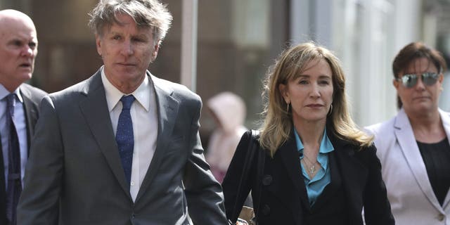 Actress Felicity Huffman arrives holding hands with her brother Moore Huffman Jr., left, at federal court in Boston on Wednesday, April 3, 2019, to face charges in a nationwide college admissions bribery scandal. (AP Photo/Charles Krupa)