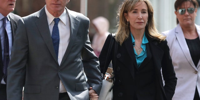 Actress Felicity Huffman arrives holding hands with her brother Moore Huffman Jr., left, at federal court in Boston on Wednesday, April 3, 2019, to face charges in a nationwide college admissions bribery scandal.