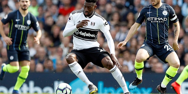 Manchester City's David Silva, right, vies for the ball with Fulham's Andre-Frank Zambo Anguissa during the English Premier League soccer match between Fulham and Manchester City at Craven Cottage stadium in London, Saturday, March 30, 2019. (AP Photo/Alastair Grant)