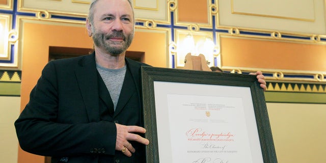 Bruce Dickinson poses for cameras with his honorary citizen certificate at the city hall in Sarajevo, Bosnia-Herzegovina, Saturday, April 6, 2019. Bosnia's capital Sarajevo has declared Iron Maiden lead singer Bruce Dickinson an honorary citizen in gratitude for the concert the heavy metal band held while the city was under siege during 1992-95 war.