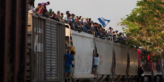 Central American migrants ride atop a freight train during their journey toward the U.S.-Mexico border, in Ixtepec, Oaxaca State, Mexico