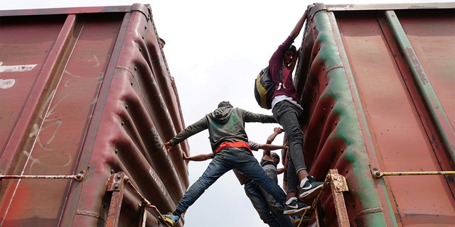 Central American migrants hang on, as they ride a train known as "The Beast", continuing their journey towards the United States, in Ixtepec, Mexico April 26, 2019.