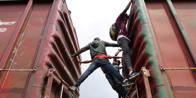 Central American migrants hang on, as they ride a train known as "The Beast", continuing their journey towards the United States, in Ixtepec, Mexico April 26, 2019.