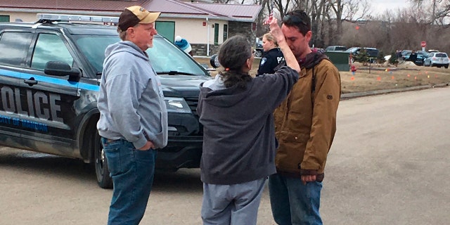 Gina Kessel, center, comforts her son Mitchell outside of RJR Maintenance and Management, a property management company, Monday, April 1, 2019, Mandan, N.D.