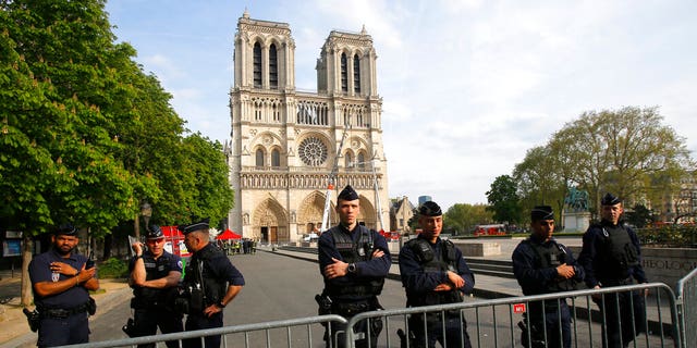 Police officers stand behind the security barriers in front of Notre Dame cathedral Thursday, April 18, 2019 in Paris.
