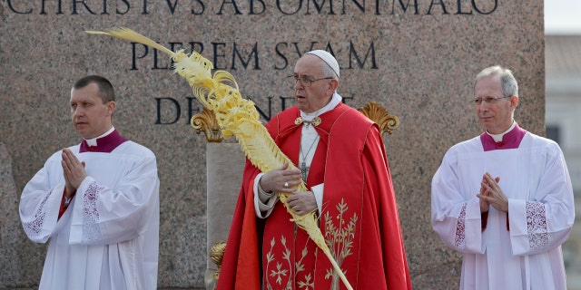 Pope Francis holds a palm frond as he celebrates a Palm Sunday Mass in St. Peter's Square at the Vatican, Sunday, April 14, 2019.
