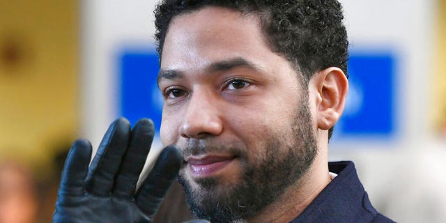 FILE - In this March 26, 2019, file photo, actor Jussie Smollett smiles and waves to supporters before leaving Cook County Court after his charges were dropped in Chicago. (AP Photo/Paul Beaty, File)