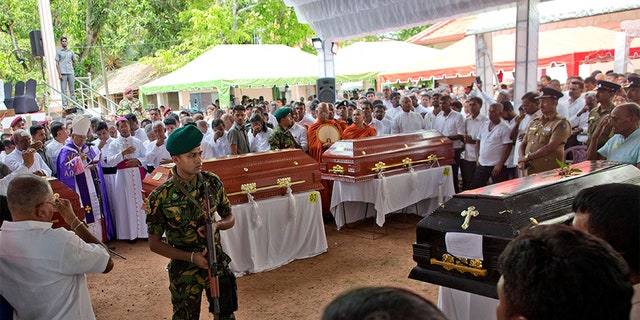 A soldier stands guard during a funeral service attended by Cardinal Malcolm Ranjith for Easter Sunday bomb blast victims at St. Sebastian Church in Negombo, Sri Lanka, on Tuesday. (AP)